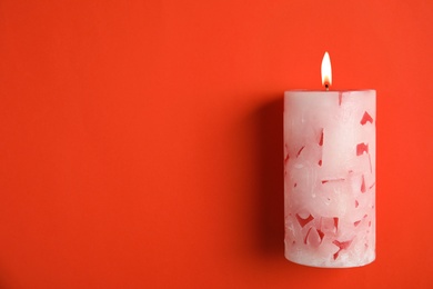 Alight wax candle and space for text on color background