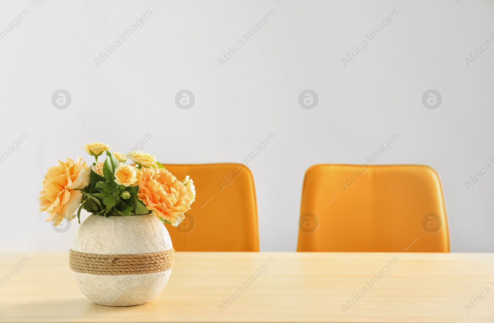 Photo of Vase with blooming flowers on table indoors