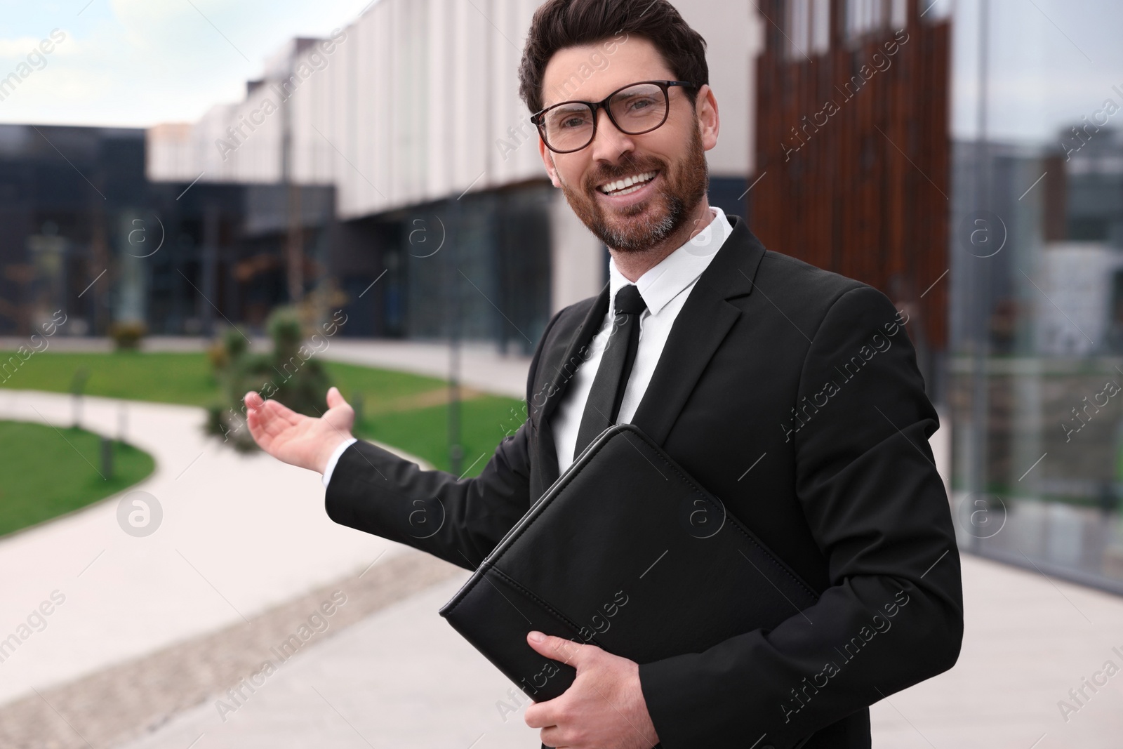 Photo of Male real estate agent with leather portfolio outdoors