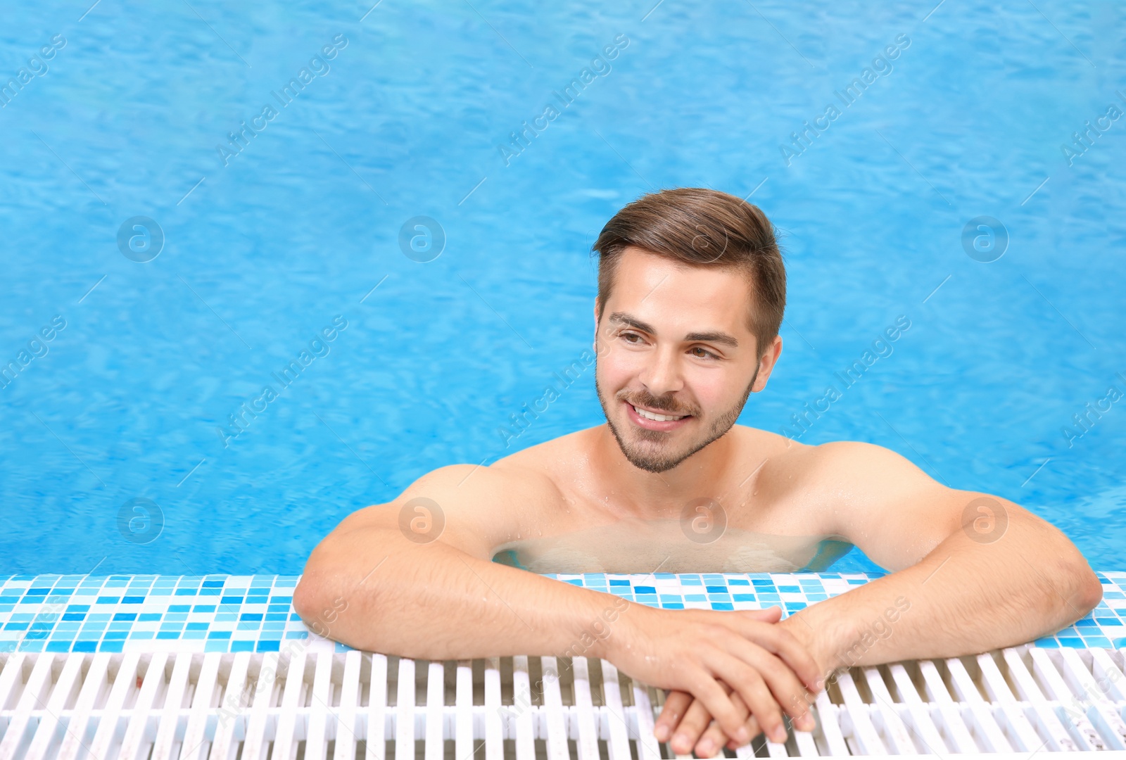 Photo of Handsome young man in swimming pool with refreshing water