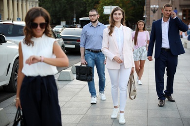 Different people walking on modern city street