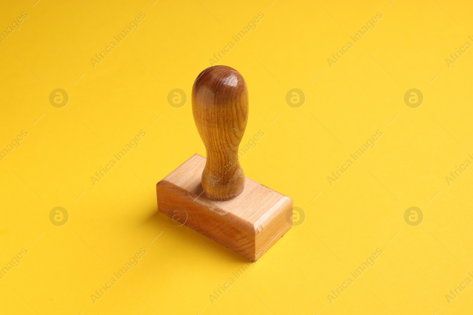 Photo of One wooden stamp tool on yellow background