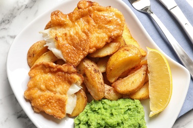 Photo of Plate with British traditional fish and potato chips, top view