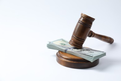 Photo of Law gavel with stack of dollars on white background. Space for text