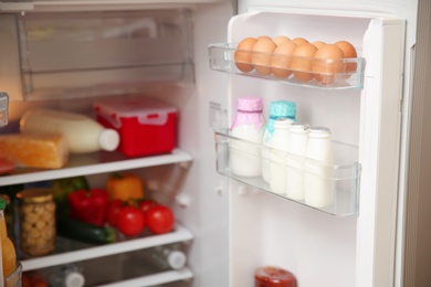 Photo of Open refrigerator with fresh food on shelves