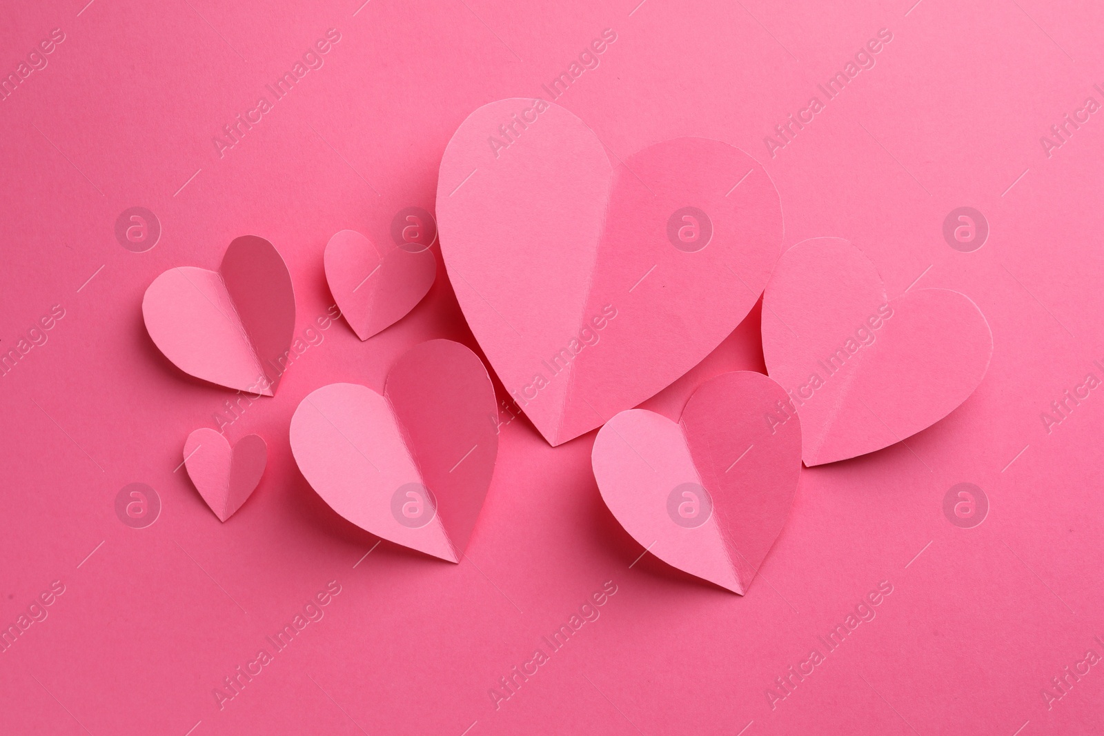 Photo of Paper hearts on pink background, flat lay