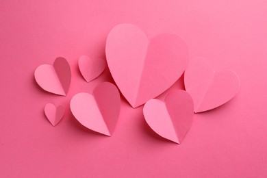 Paper hearts on pink background, flat lay