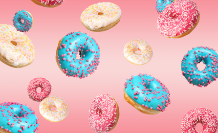 Set of falling delicious donuts on pink background