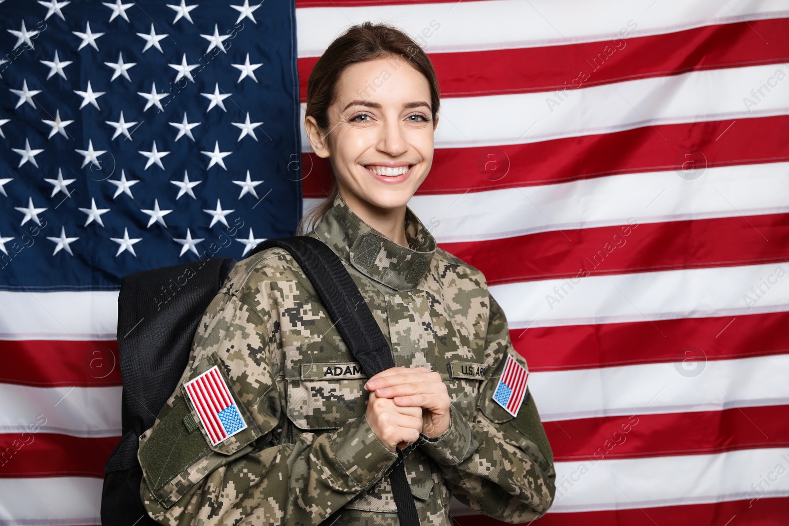 Photo of Female cadet with backpack against American flag. Military education