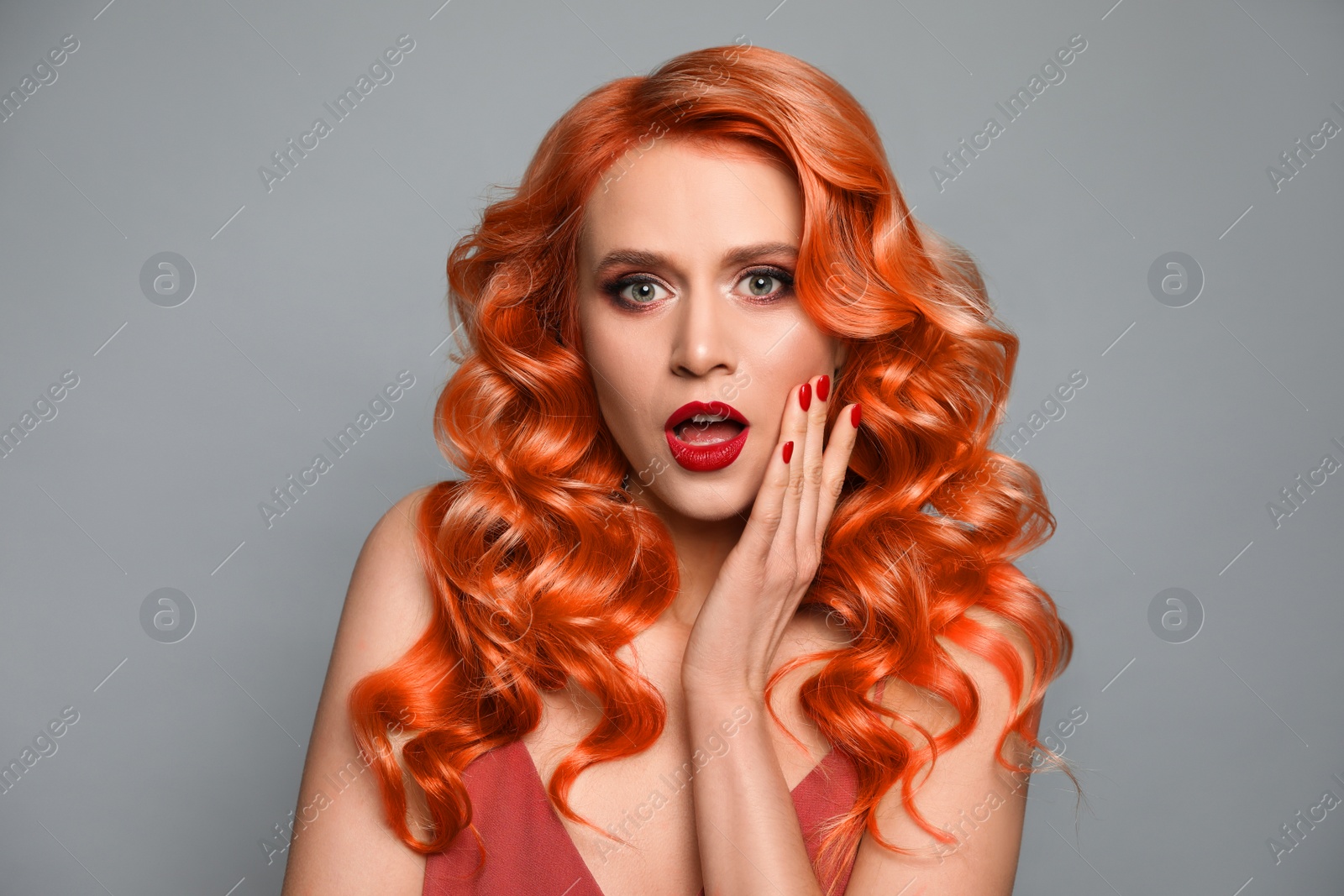 Image of Beautiful woman with long orange hair on light grey background