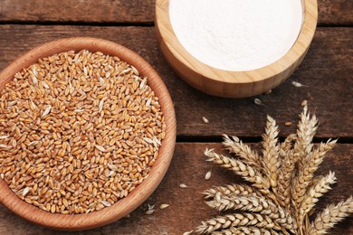 Photo of Wheat grains and flour in bowls on wooden table