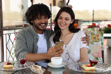 Photo of International dating. Happy couple spending time together in restaurant
