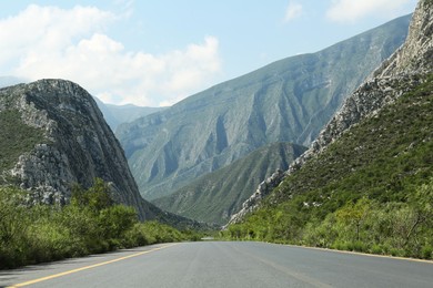 Picturesque view of big mountains and bushes near road