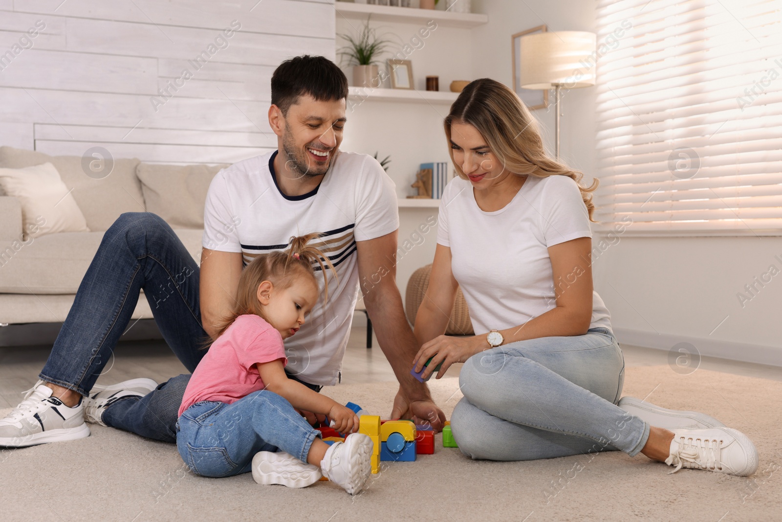 Photo of Family with little daughter spending time together at home