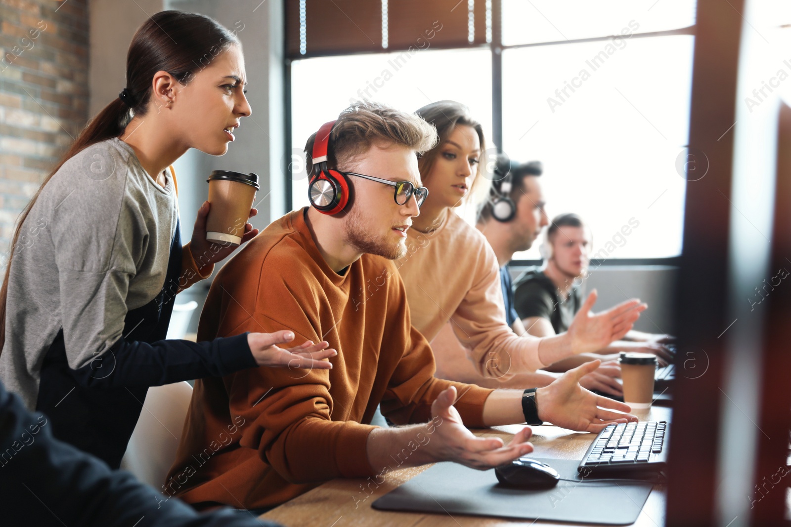 Photo of Group of people playing video games in internet cafe