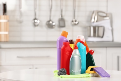 Photo of Set of cleaning supplies on table in kitchen. Space for text