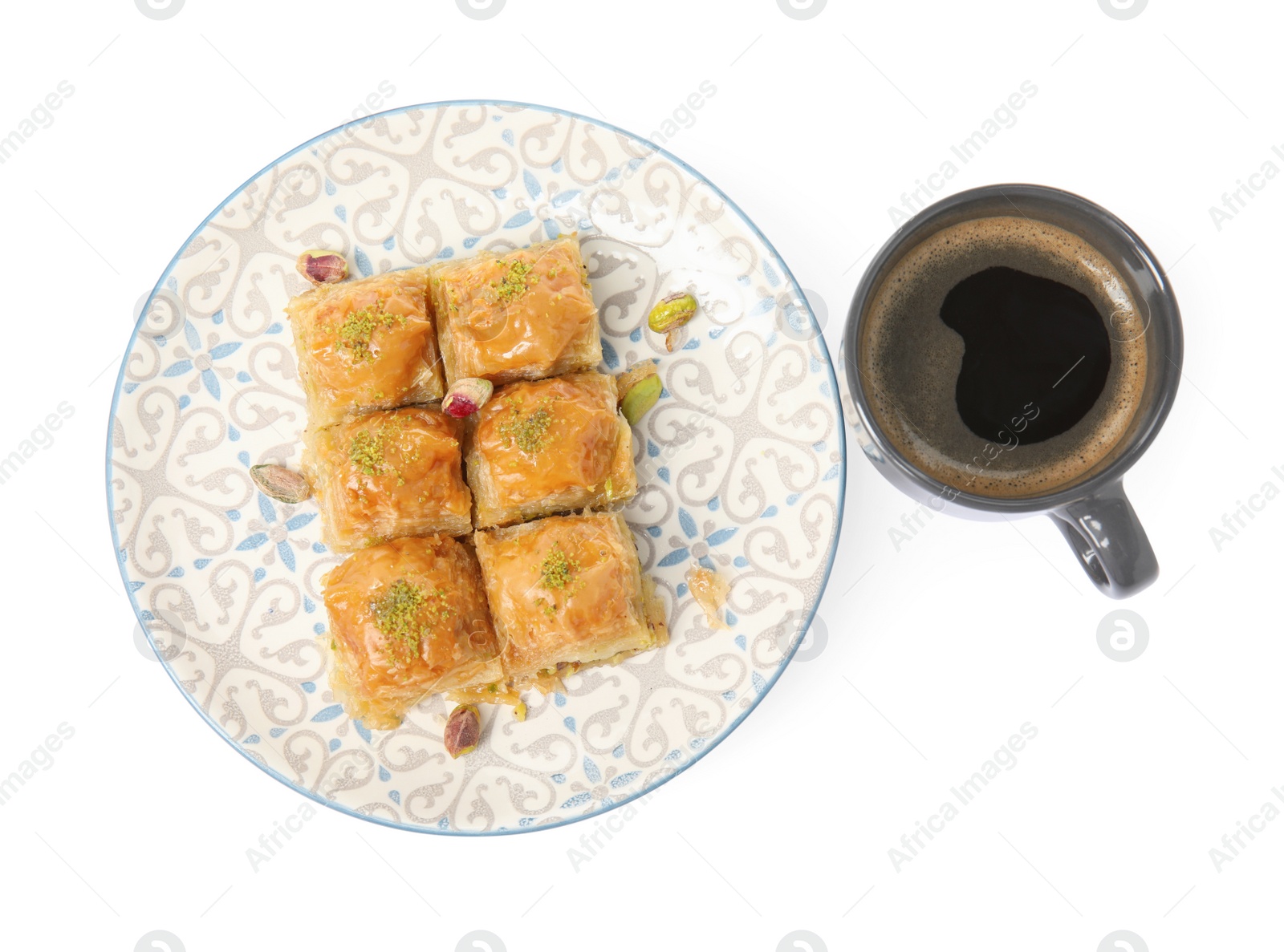 Photo of Delicious baklava with pistachios and hot coffee on white background, top view