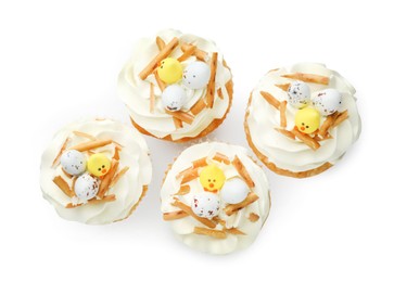 Photo of Tasty Easter cupcakes with vanilla cream isolated on white, top view