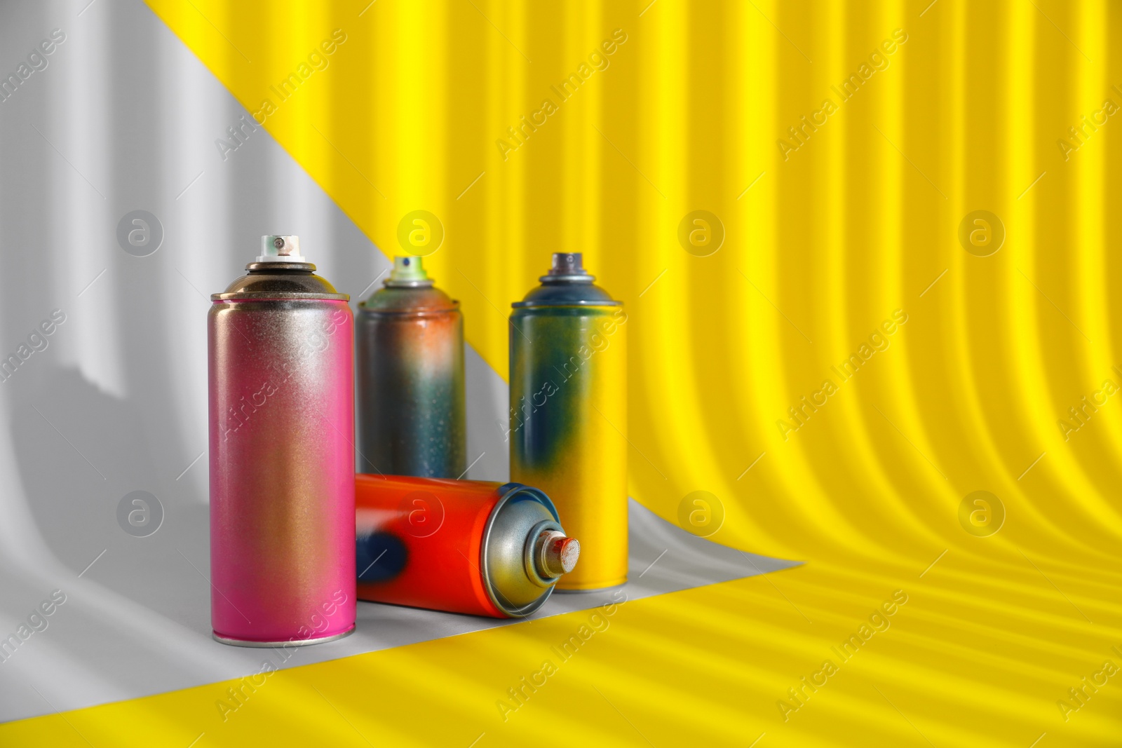 Photo of Used cans of spray paints on color background. Space for text