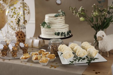 Beautiful cake and other treats on table in room. Baby shower party