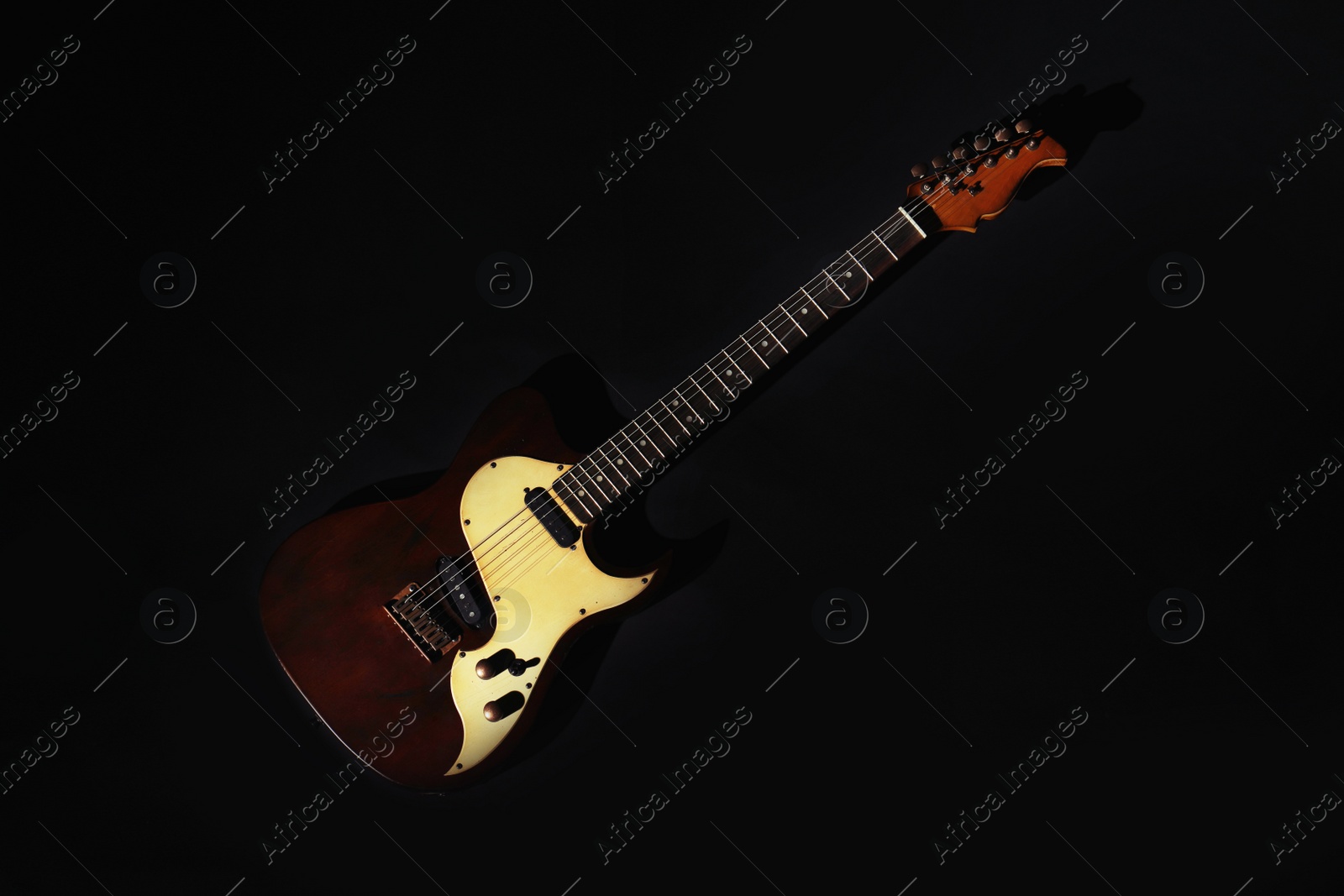 Photo of Electric guitar on black background, top view. Musical instrument