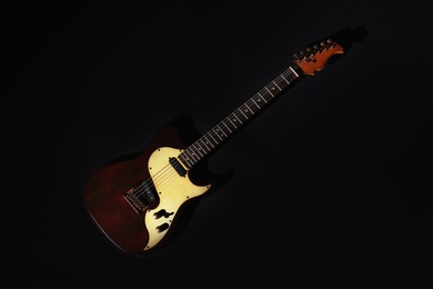 Electric guitar on black background, top view. Musical instrument