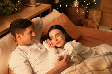 Photo of Happy couple in bed at home. Christmas celebration