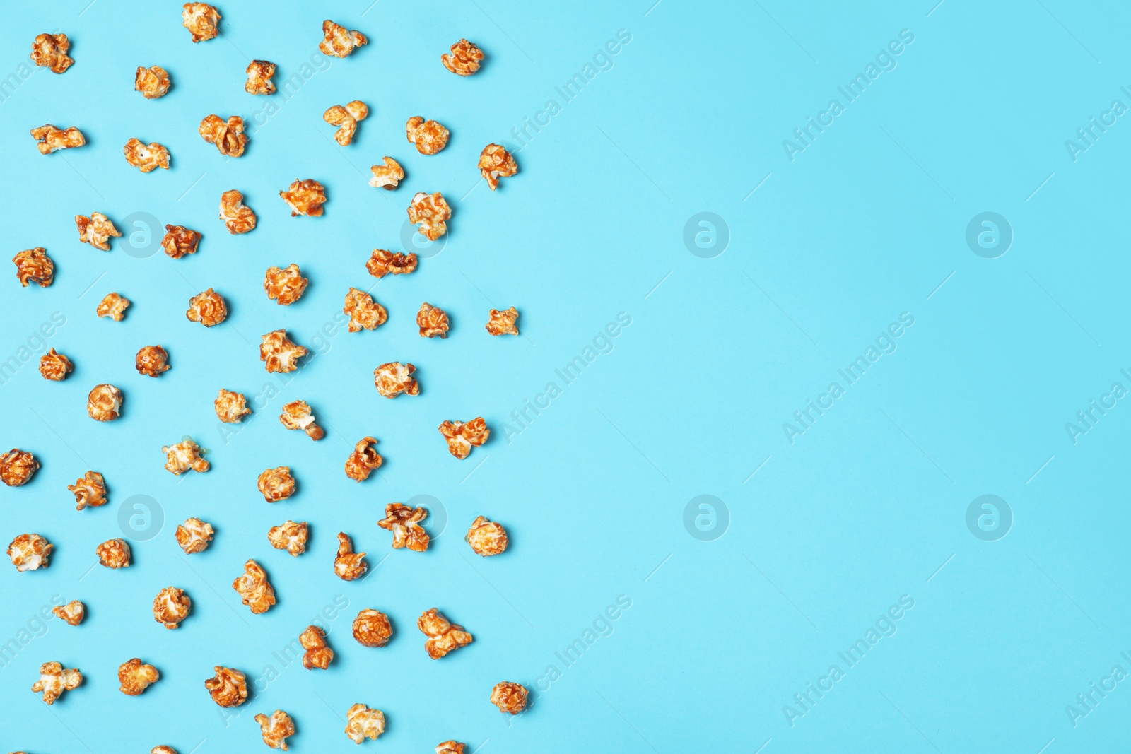 Photo of Flat lay composition with caramel popcorn and space for text on color background