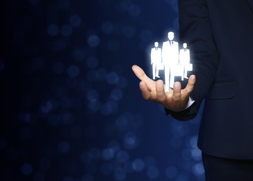 Image of Man presenting virtual icons of businesspeople on dark background, closeup view with space for text. Leadership concept