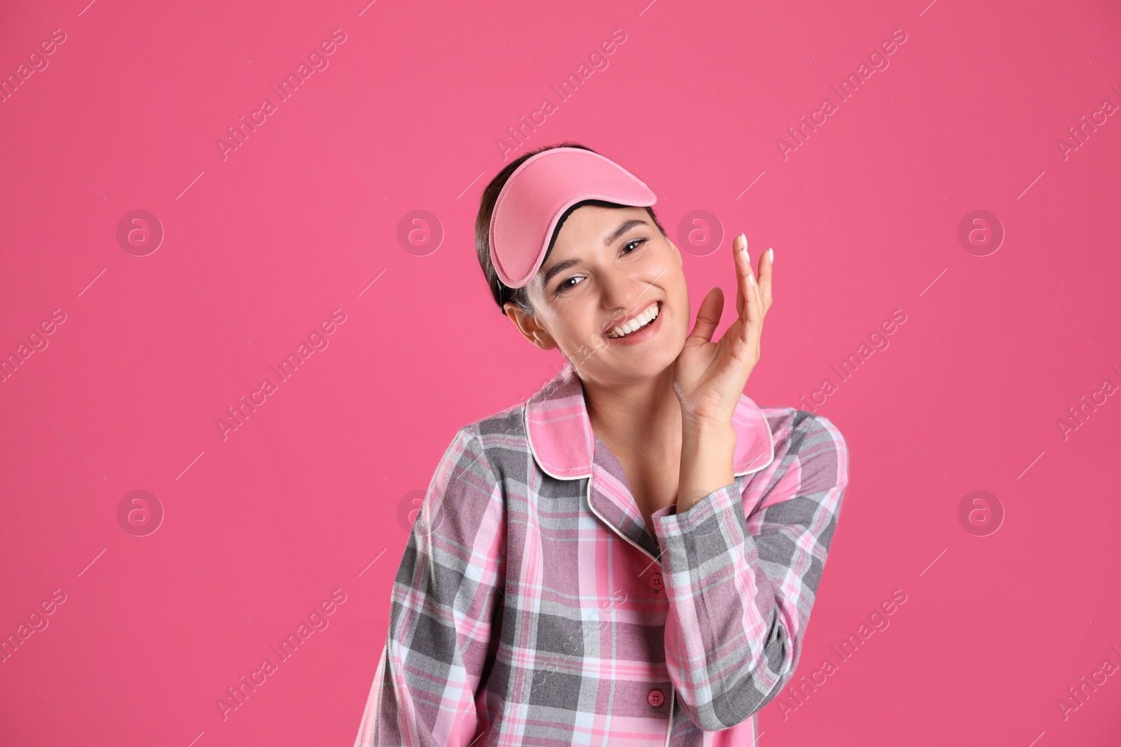 Photo of Beautiful woman wearing sleeping mask on pink background. Bedtime