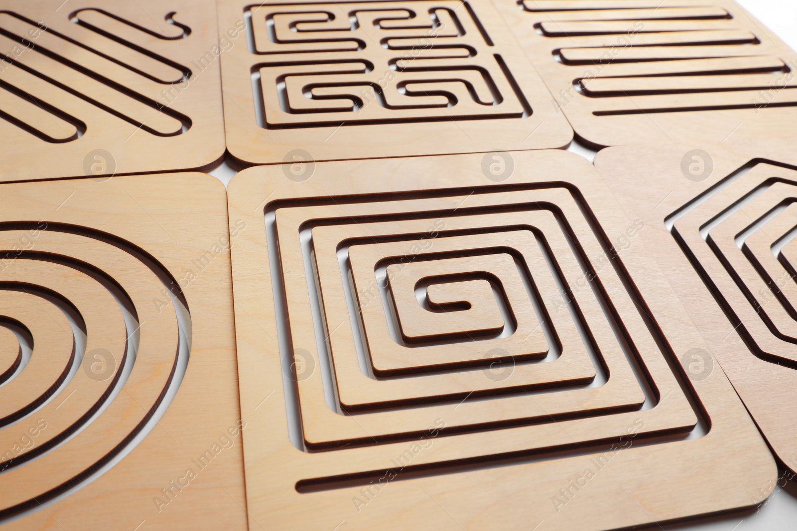 Photo of Wooden finger labyrinths on white background, closeup. Montessori toy