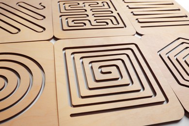 Photo of Wooden finger labyrinths on white background, closeup. Montessori toy