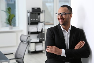 Photo of Smiling young businessman in office. Space for text