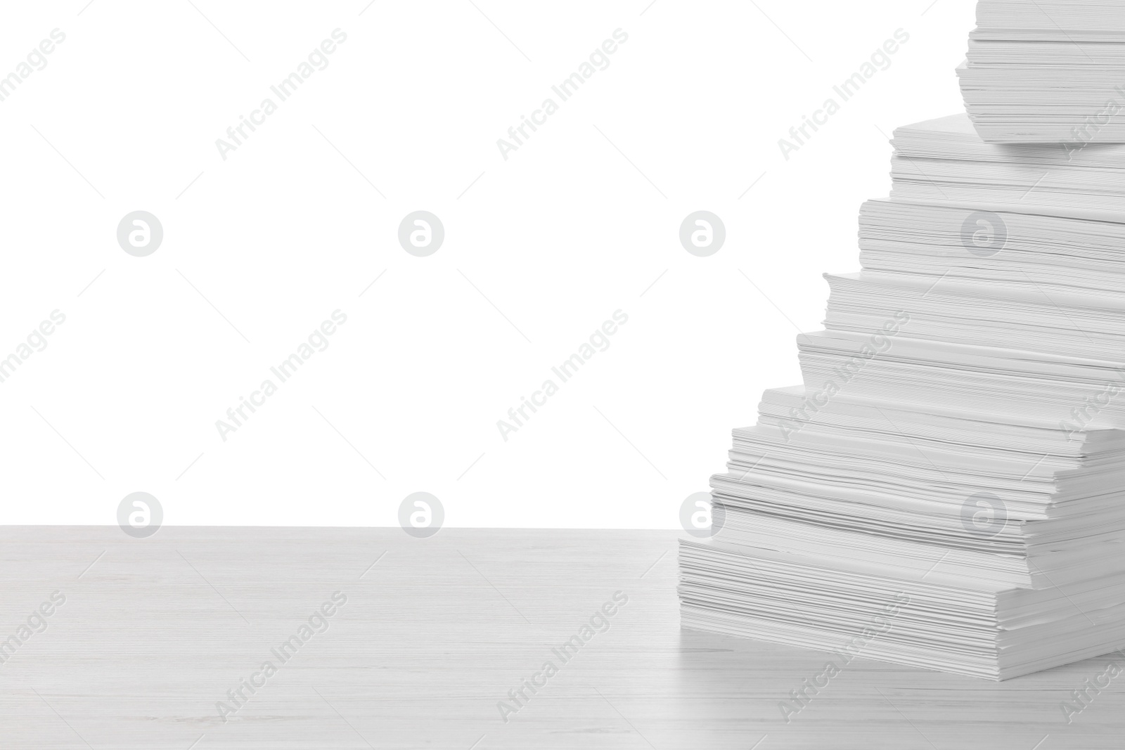 Photo of Stack of paper sheets on light wooden table against white background. Space for text