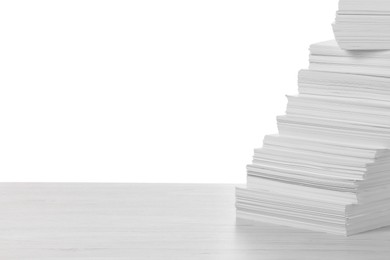 Stack of paper sheets on light wooden table against white background. Space for text