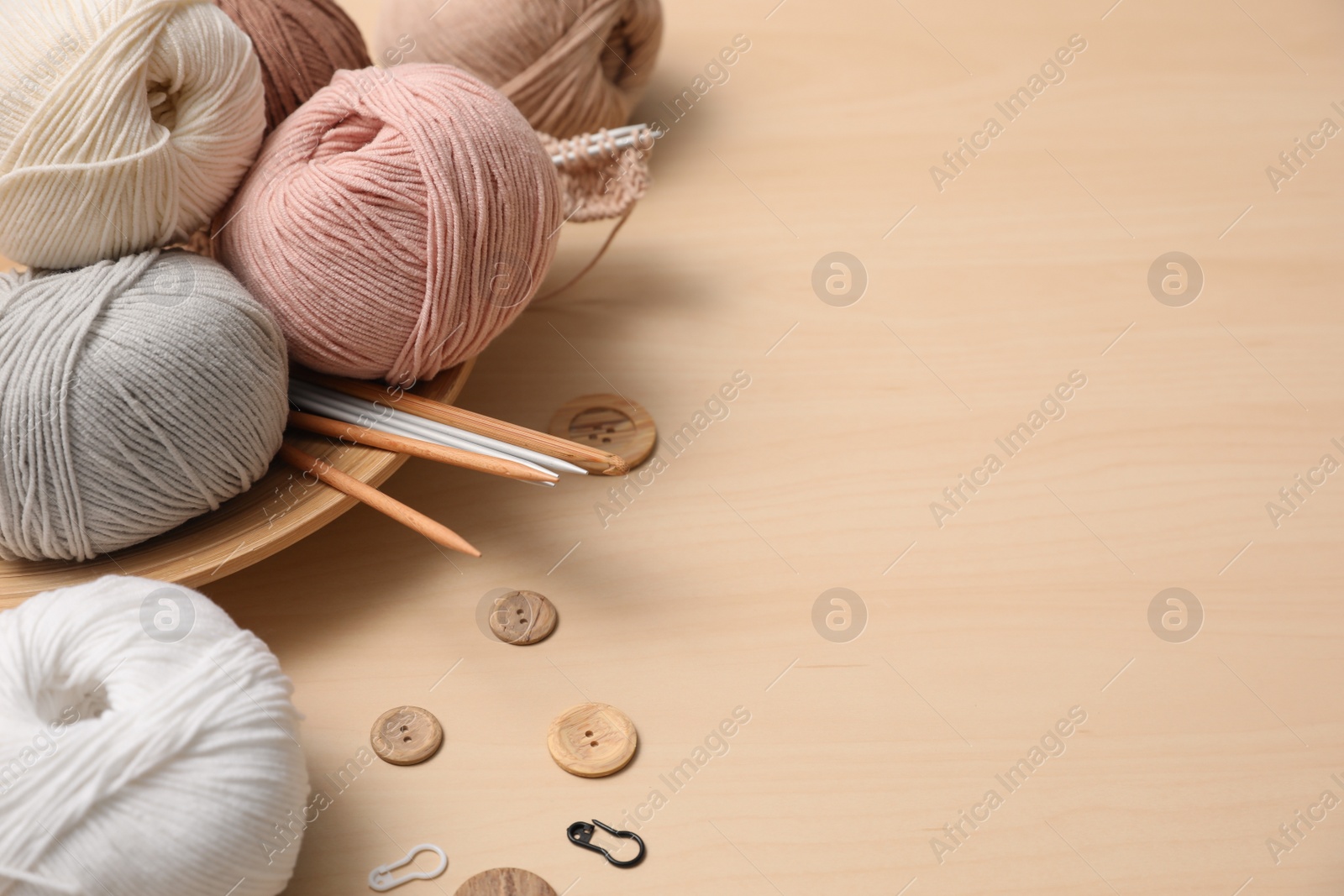 Photo of Composition with threads and crafting accessories on wooden table, space for text. Engaging hobby