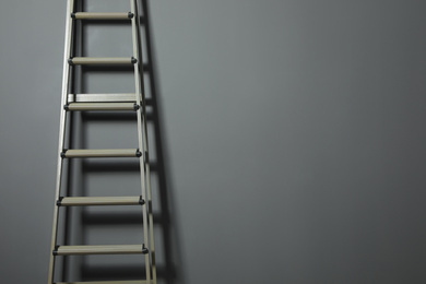 Metal stepladder on grey background. Space for text
