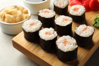 Photo of Tasty sushi rolls served on grey table, closeup