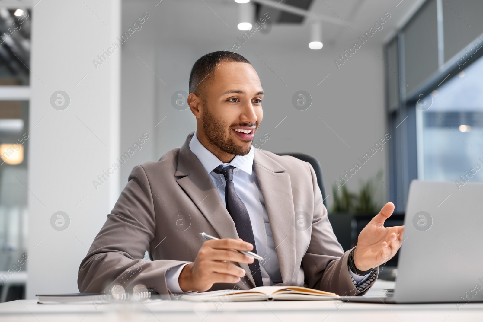 Photo of Happy man working at table in office. Lawyer, businessman, accountant or manager