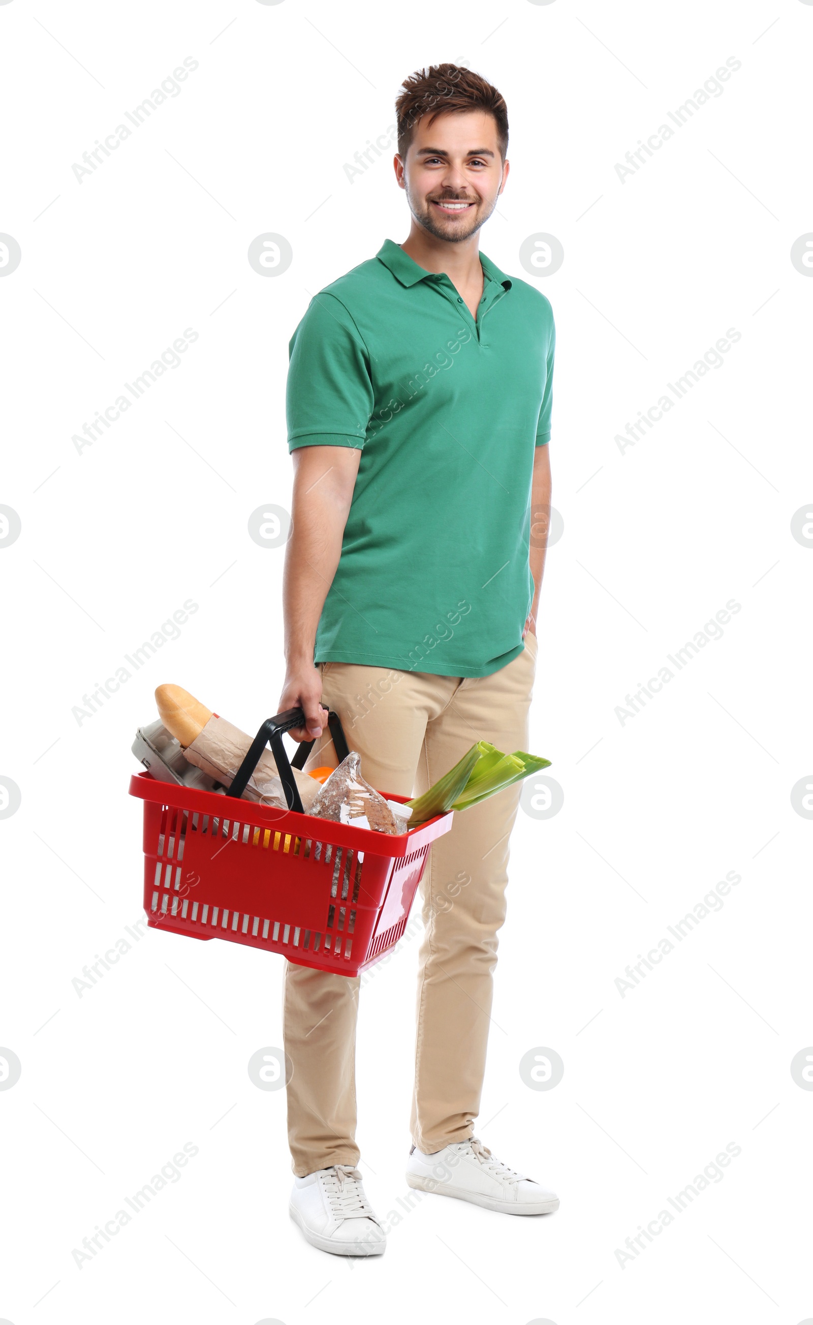 Photo of Young man with shopping basket full of products isolated on white