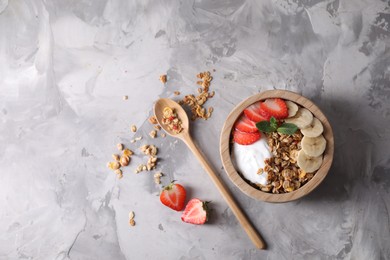 Tasty granola served on gray textured table, flat lay. Space for text