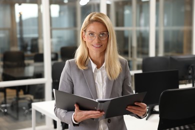 Photo of Smiling woman with folder in office. Lawyer, businesswoman, accountant or manager