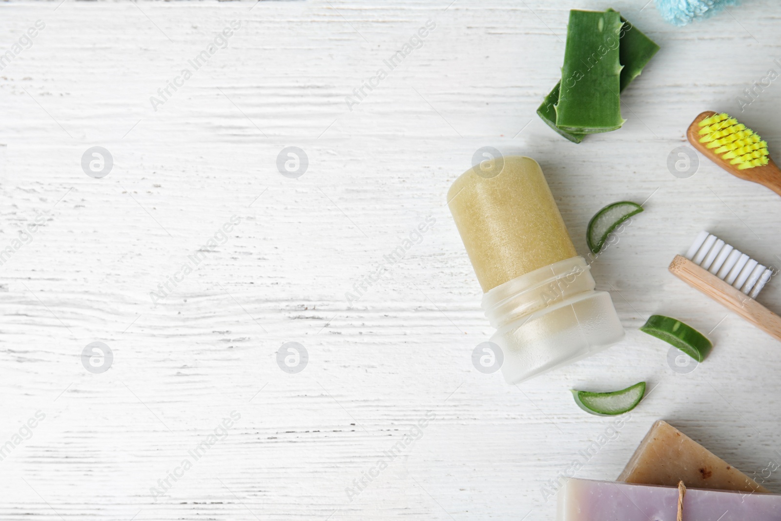 Photo of Flat lay composition with natural crystal alum deodorant and space for text on white wooden table