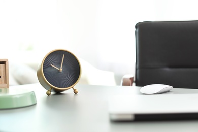 Stylish alarm clock on table in office. Time to work