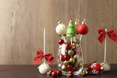 Photo of Delicious Christmas themed cake pops on wooden table