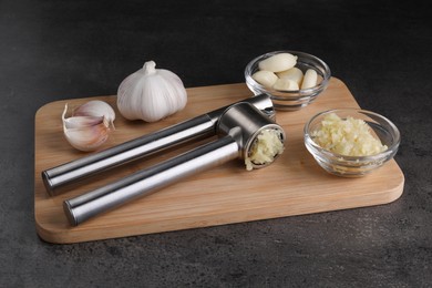 Photo of Garlic press and mince on grey table. Kitchen utensil