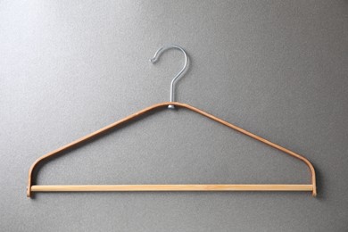 Photo of One wooden hanger on grey background, top view
