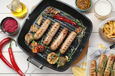 Photo of Tasty grilled sausages served on white wooden table, flat lay