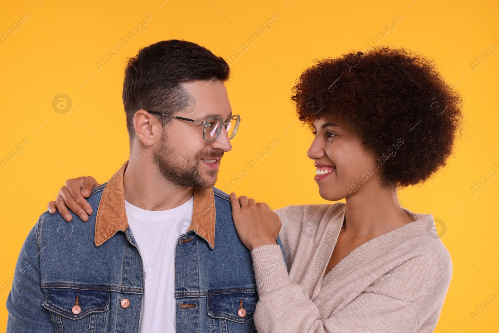 Photo of International dating. Portrait of happy couple on orange background