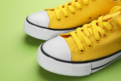Pair of trendy sneakers on green background, closeup